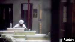 An unidentified prisoner reads a newspaper in a communal cellblock at Camp VI, a prison used to house detainees at Guantanamo Bay U.S. Naval Base, March 5, 2013